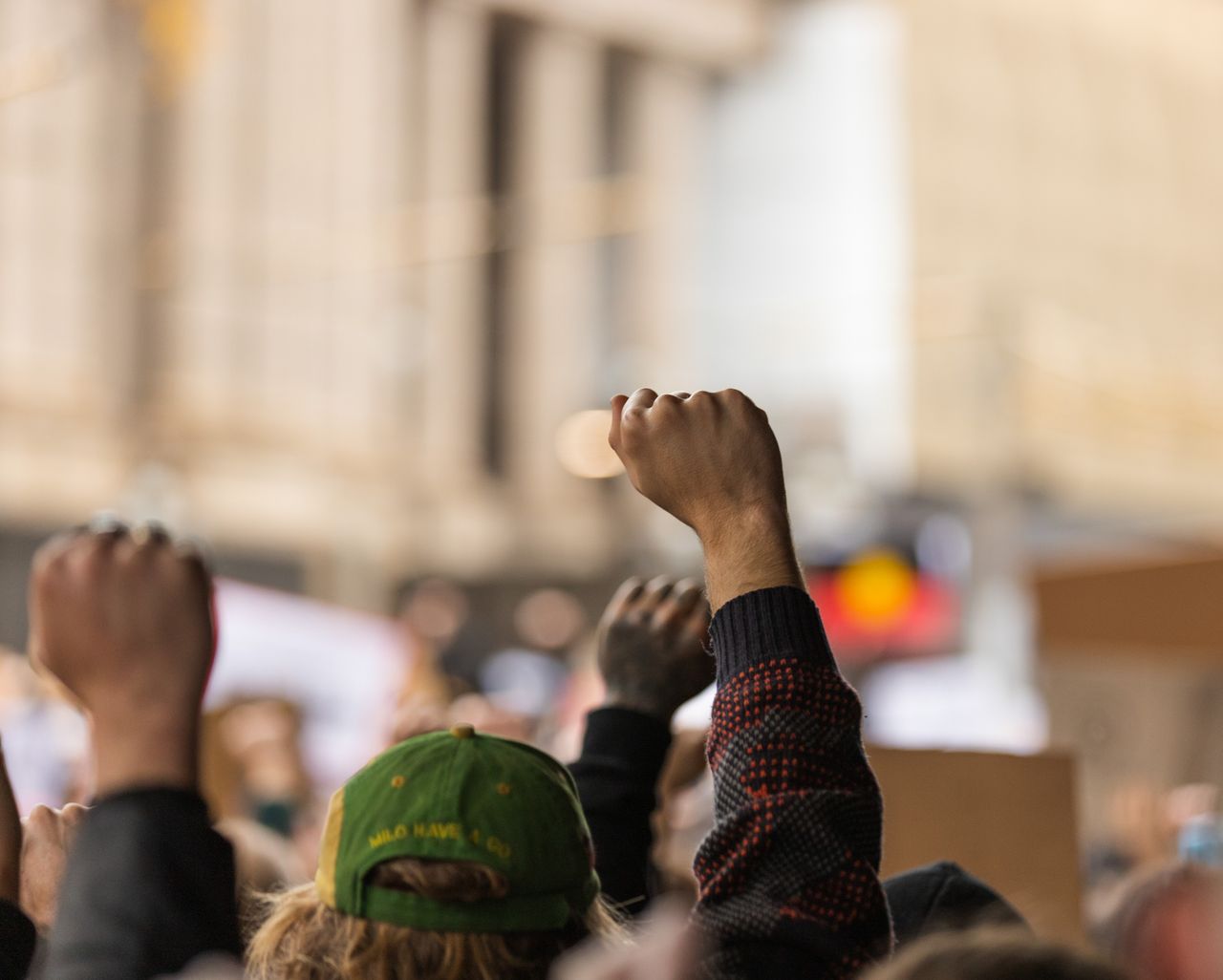 services-02 A powerful image of raised fists symbolizing unity during a protest in Melbourne's streets.