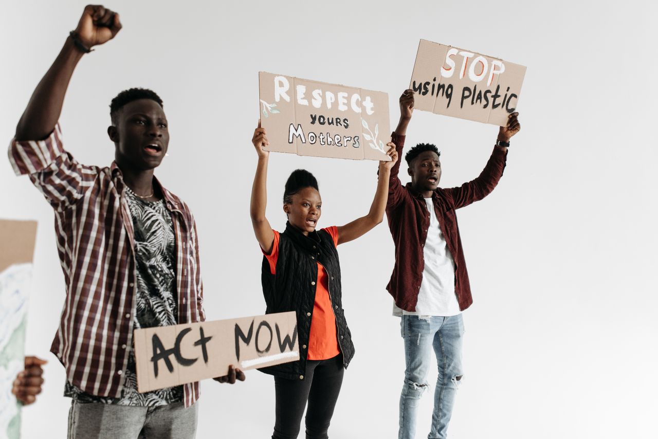services-03 Young adults holding protest signs advocating for respect and environmental awareness.